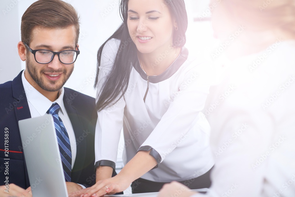 Business people at a meeting in the office. Focus on woman pointing into laptop Business people at a meeting in the office. Focus on woman pointing into laptop