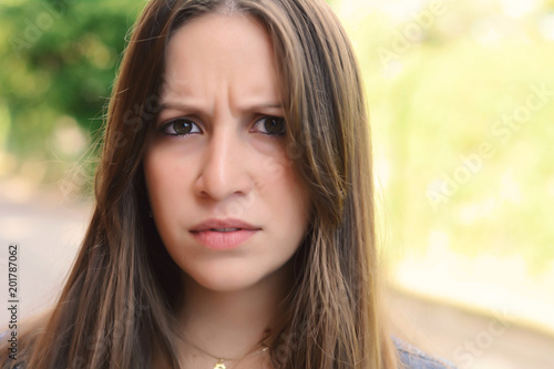 Young woman having uncertain and frustrated look.