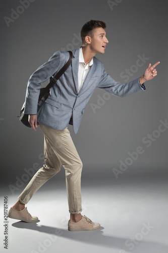 Punctuality concept. Side view profile of pleased good looking man running with backpack