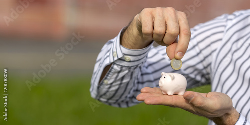 Cute little piggy bank in your hand