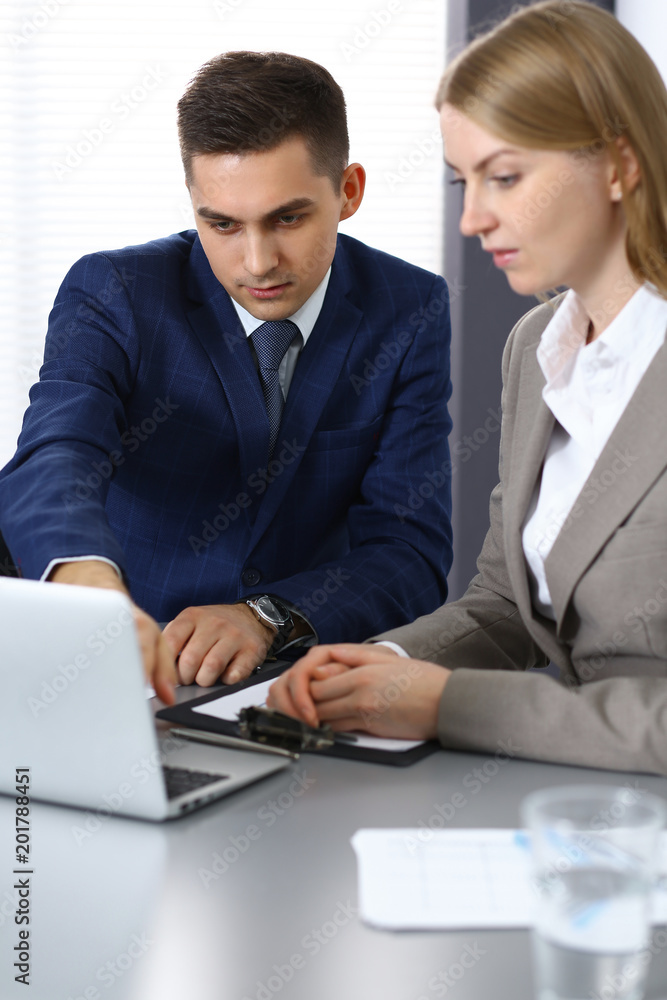 Business people using laptop pc while discussing project in office Business people using laptop pc while discussing project in office