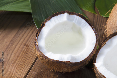 natural coconut on wood with green leaves