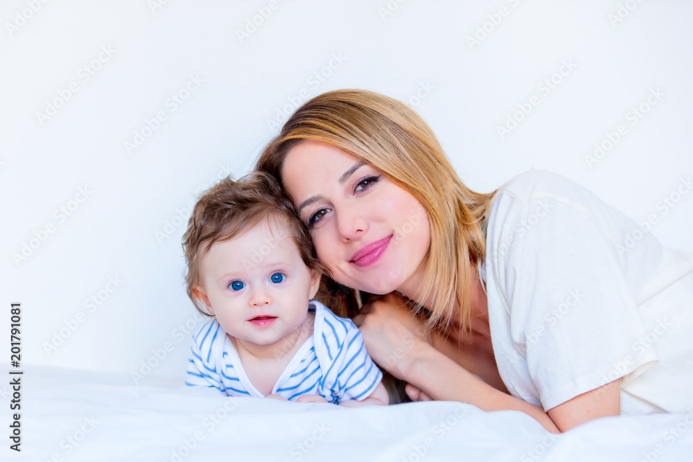 Young mother and little child boy lying down in white bed Young mother and little child boy lying down in white bed