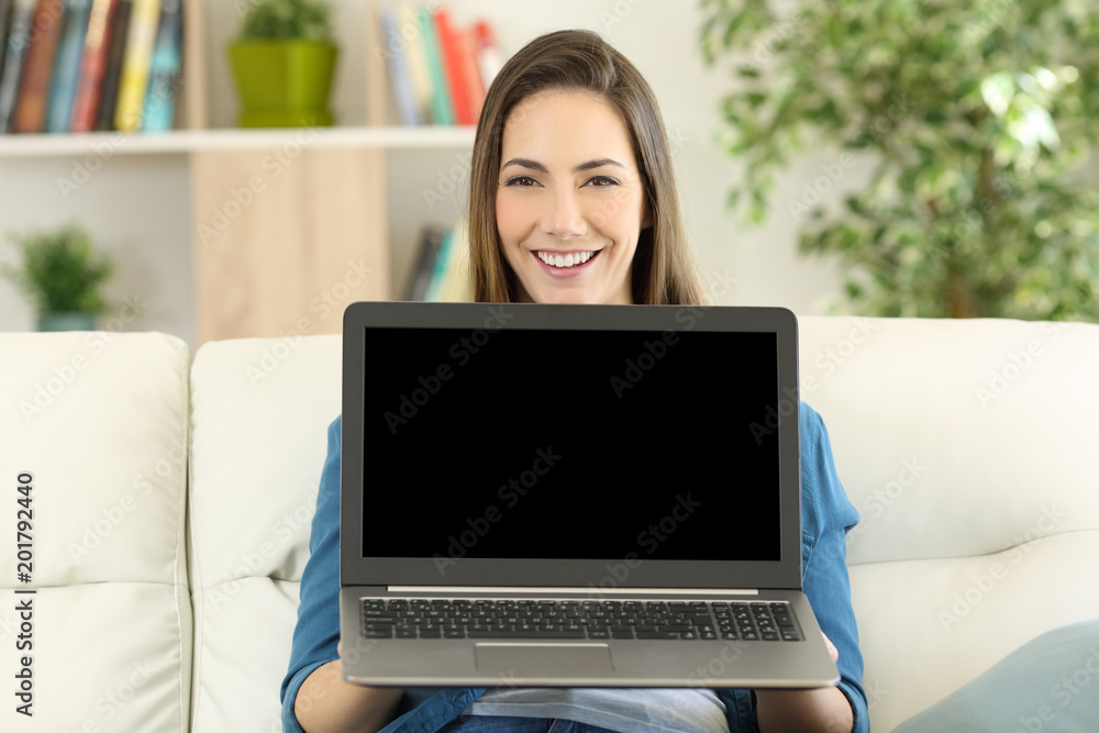 Woman showing a blank laptop screen at home Woman showing a blank laptop screen at home