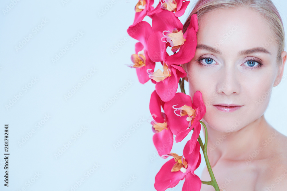 Young beauty woman with flower near face