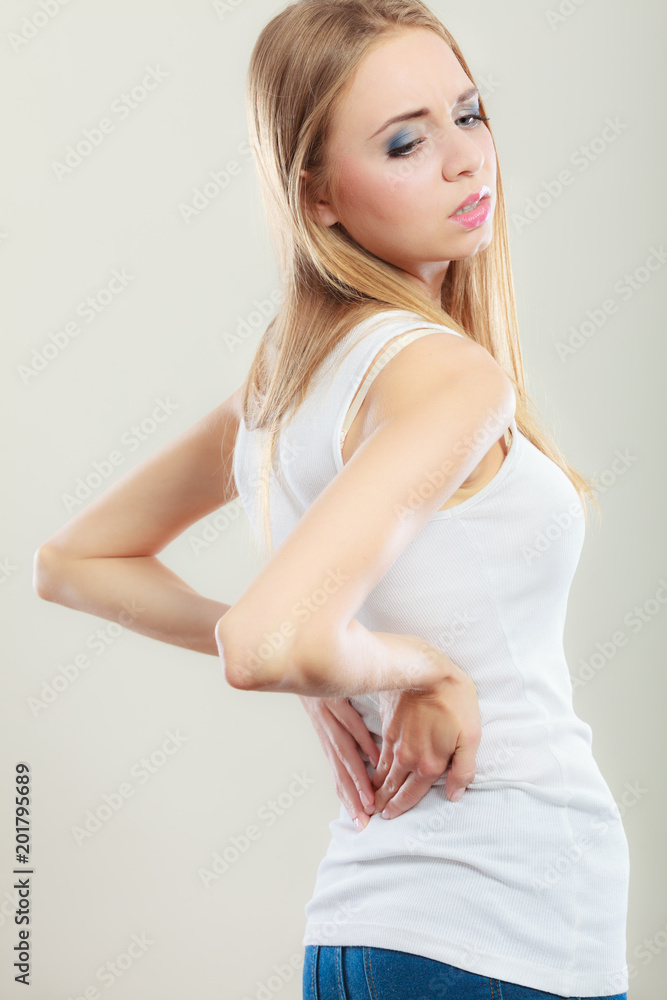Backache. Young woman suffering from back pain Backache. Young woman suffering from back pain