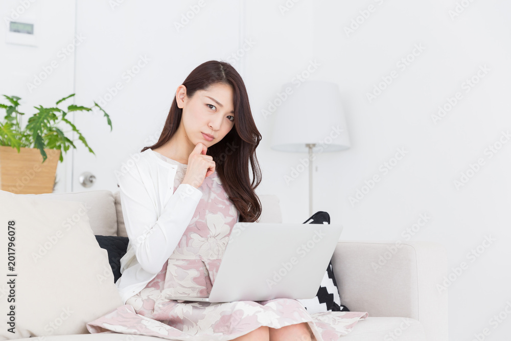 ラップトップコンピュータを見る女性　考える