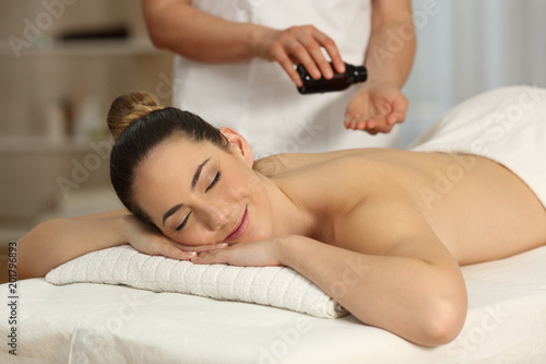 Massage therapist applying oil in hands