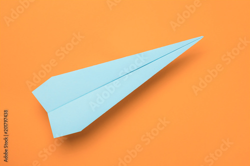Blue paper plane on orange