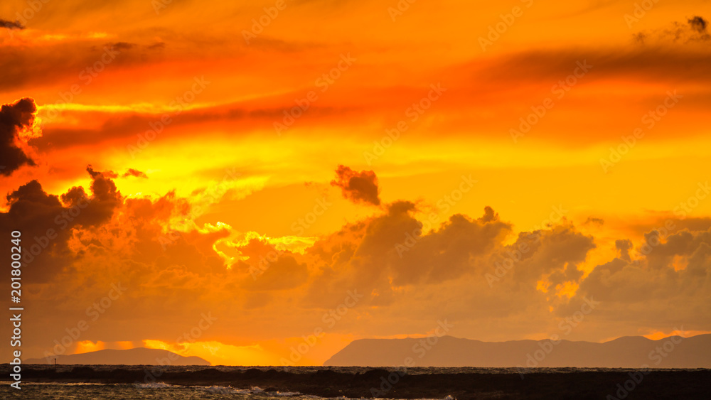 Sunset over sea surface, dark clouds.