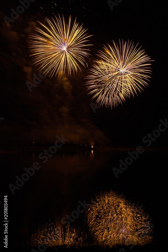 Photography Fireworks of many colors on  display and refelcting in a lake