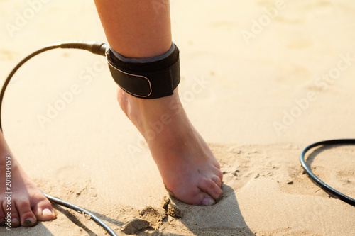 Surfing leash on female leg close up