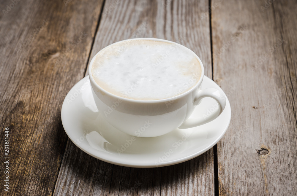 Sweet coffee latte in white cup on the rustic background. Selective focus. Sweet coffee latte in white cup on the rustic background. Selective focus.