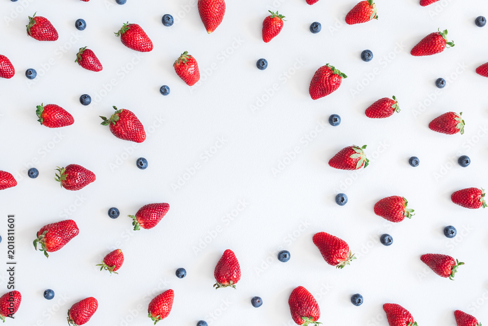 Fruit pattern. Strawberry and blueberry on blue background. Flat lay, top view, copy space