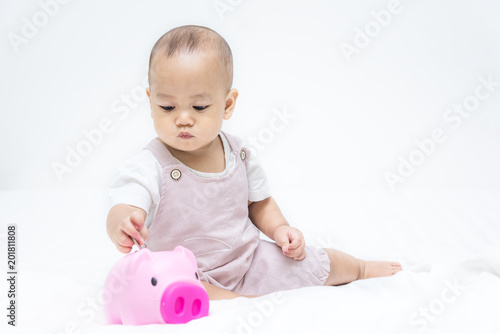 Baby save money to pink piggy bang on the bed