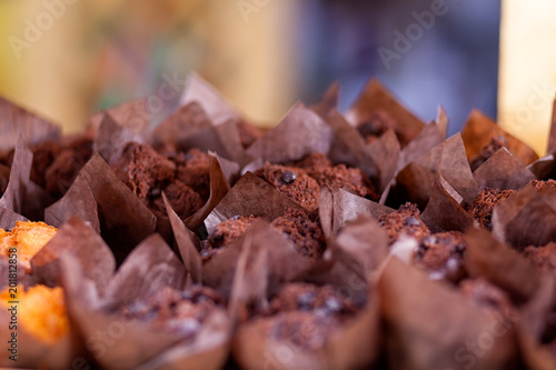 Close-up of fresh chocolate muffins, decorated with chocolate and with hot chocolate inside the even rows