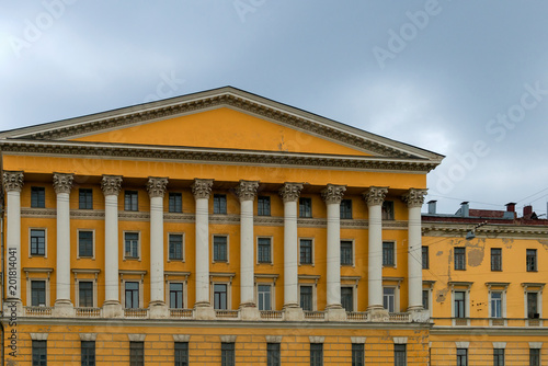 View from the water to a beautiful yellow building with columns on the embankment of St. Petersburg, Russia, symmetry, architecture photo