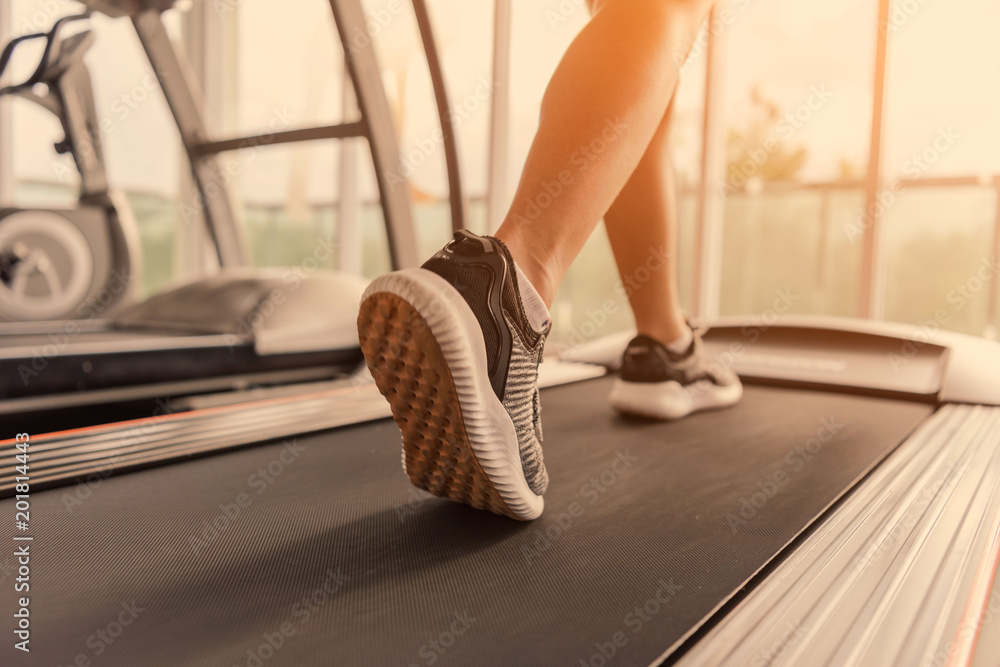 Exercise treadmill cardio running workout at fitness gym of woman