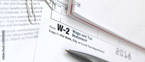 The pen and notebook on the tax form W-2 Wage and Tax Statement. The time to pay taxes