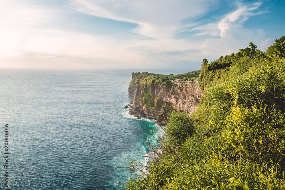Blue ocean and cliff with trees in Uluwatu, Bali