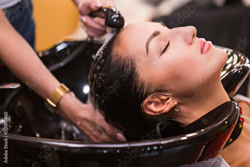 Close up portrait of woman which wash hair in a beauty salon. Care and hair products