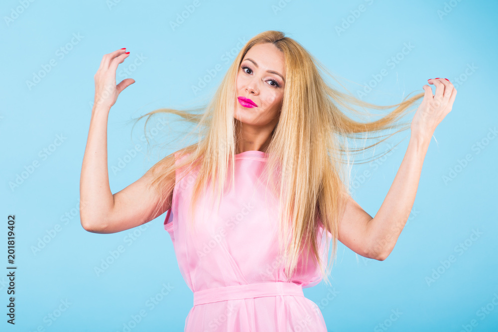 Portrait of smiling blonde woman in fashionable look on blue background. Style, fashion, summer and people concept Portrait of smiling blonde woman in fashionable look on blue background. Style, fashion, summer and people concept