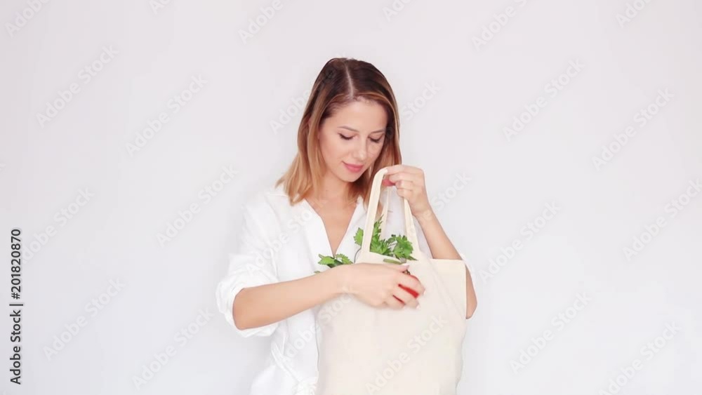 woman in white clothes showing bag with different vegetables woman in white clothes showing bag with different vegetables