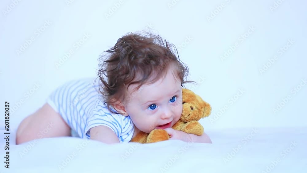 Little child boy with blue eyes and teddy bear in white bed Little child boy with blue eyes and teddy bear in white bed
