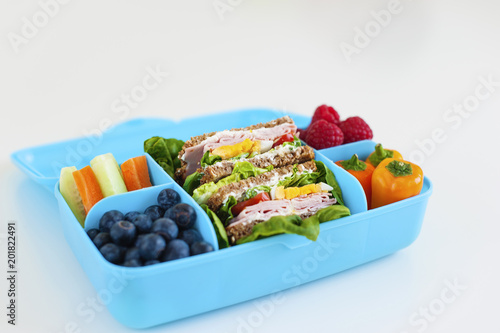 Blue lunch box with healthy food. Side view
