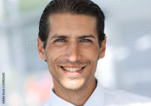 face of young businessman on background of office