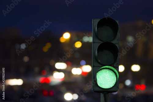 traffic light green signal on the night on the back lights of cars. 