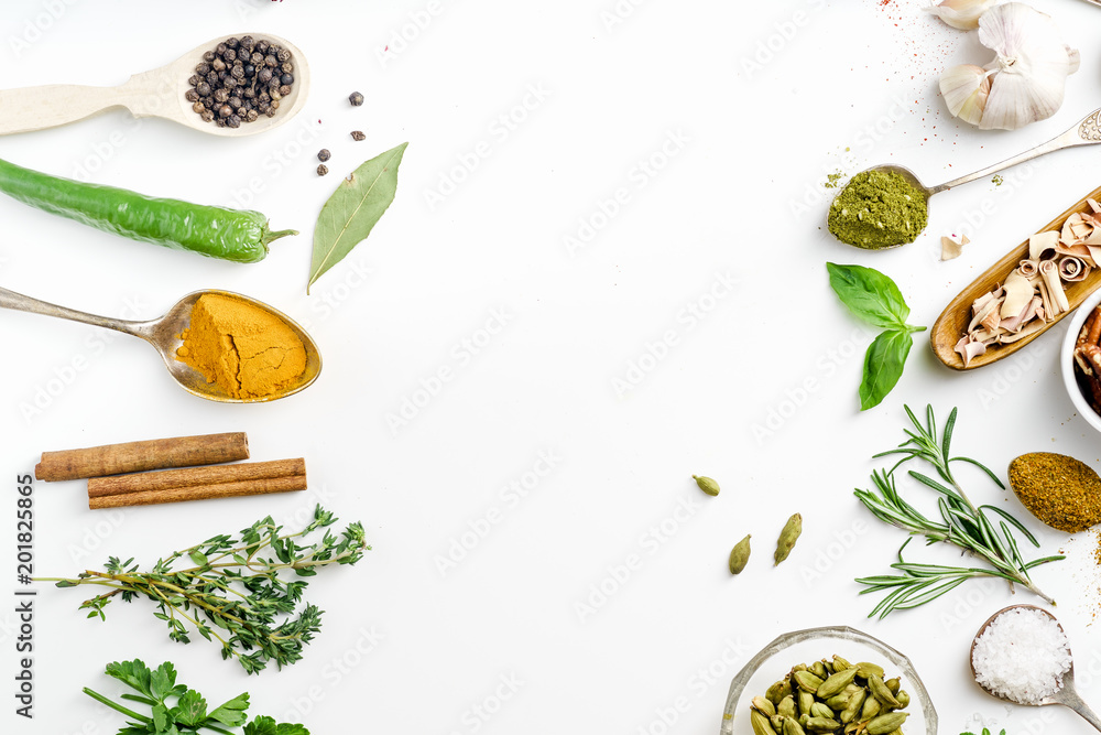 Fresh herbs and dried colorful spices in spoons and bowls arranged in frame on white background with copy space inside Fresh herbs and dried colorful spices in spoons and bowls arranged in frame on white background with copy space inside