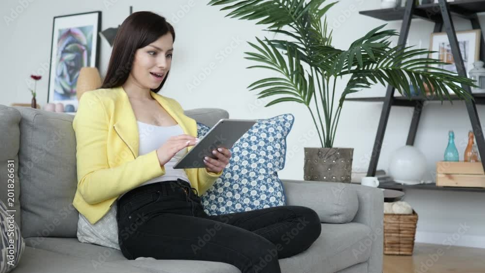 Shocked, Positive Beautiful Woman Wondering while Using Tablet Computer Shocked, Positive Beautiful Woman Wondering while Using Tablet Computer