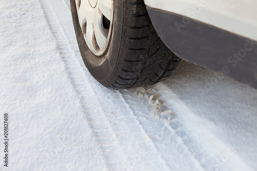Detail of car wheel's tyre imprint on the snow. Winter tire imprint closeup shot. Pneumatic press into track in the snow. Day coach tyre impress on snow. Passenger carriage rubber ectype. photo