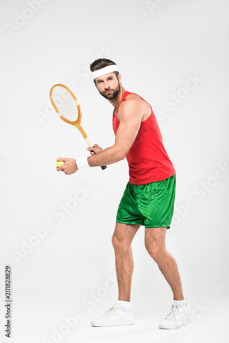 sportsman playing tennis with retro wooden racket and ball, isolated on white © LIGHTFIELD STUDIOS