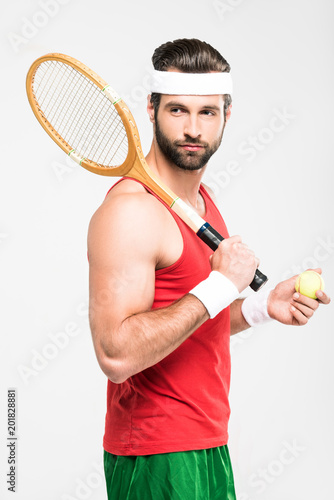 muscular tennis player holding retro wooden racket and ball, isolated on white © LIGHTFIELD STUDIOS