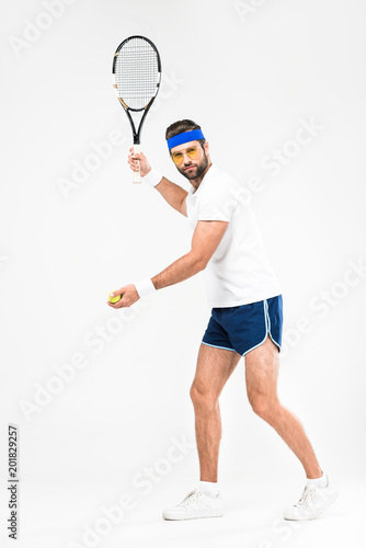 sportsman in retro sunglasses playing tennis with racket and ball, isolated on white © LIGHTFIELD STUDIOS