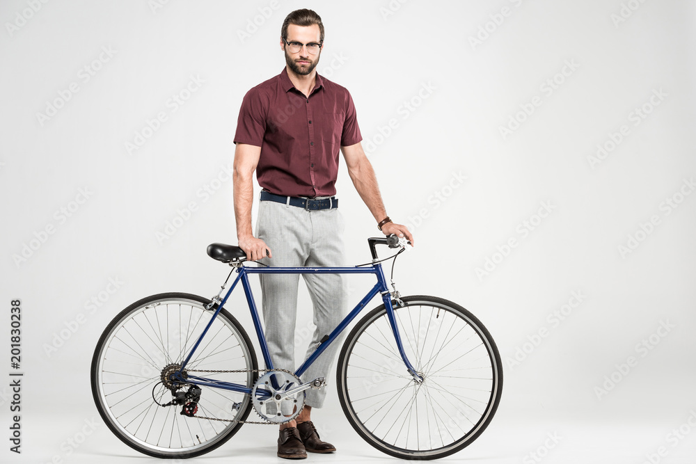 stylish man posing with bike, isolated on grey stylish man posing with bike, isolated on grey