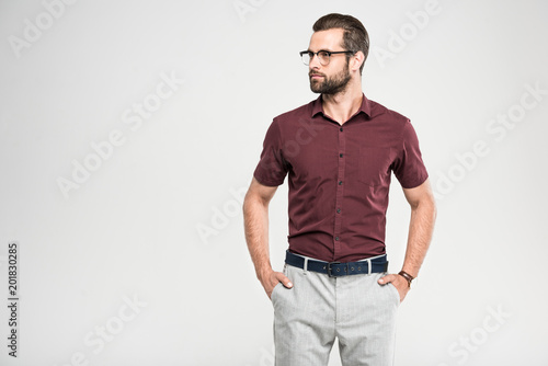 handsome serious man posing in casual closing and glasses, isolated on grey