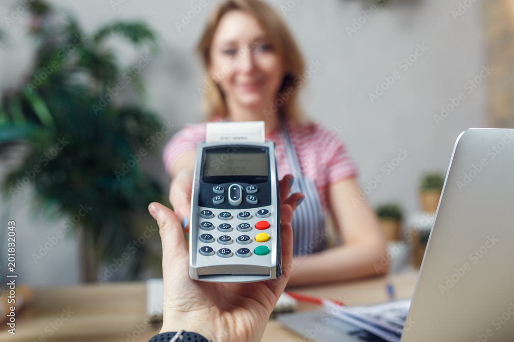 Picture of florist with calculator at table with laptop Picture of florist with calculator at table with laptop
