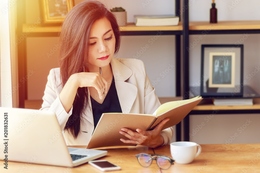 young Asian business woman working at workplace. beautiful Asian woman in casual suit working with reading book, prepare for meeting or interview in modern office. freelance and start up business in A young Asian business woman working at workplace. beautiful Asian woman in casual suit working with reading book, prepare for meeting or interview in modern office. freelance and start up business in A