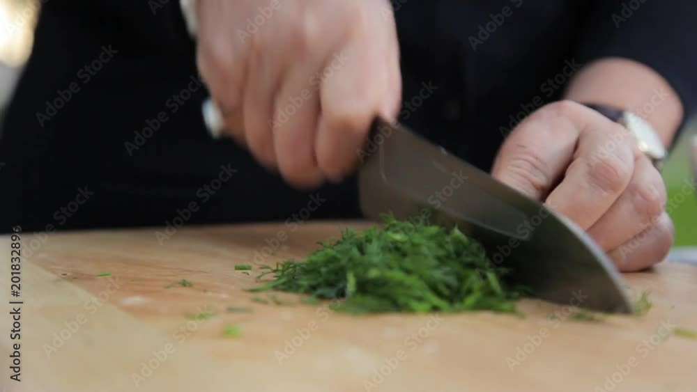 A close up shot of chopping spice on a wooden chopping board. A close up shot of chopping spice on a wooden chopping board.
