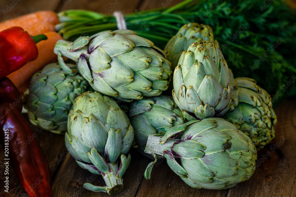 Obraz premium artichokes, peppers and carrots on wooden table
