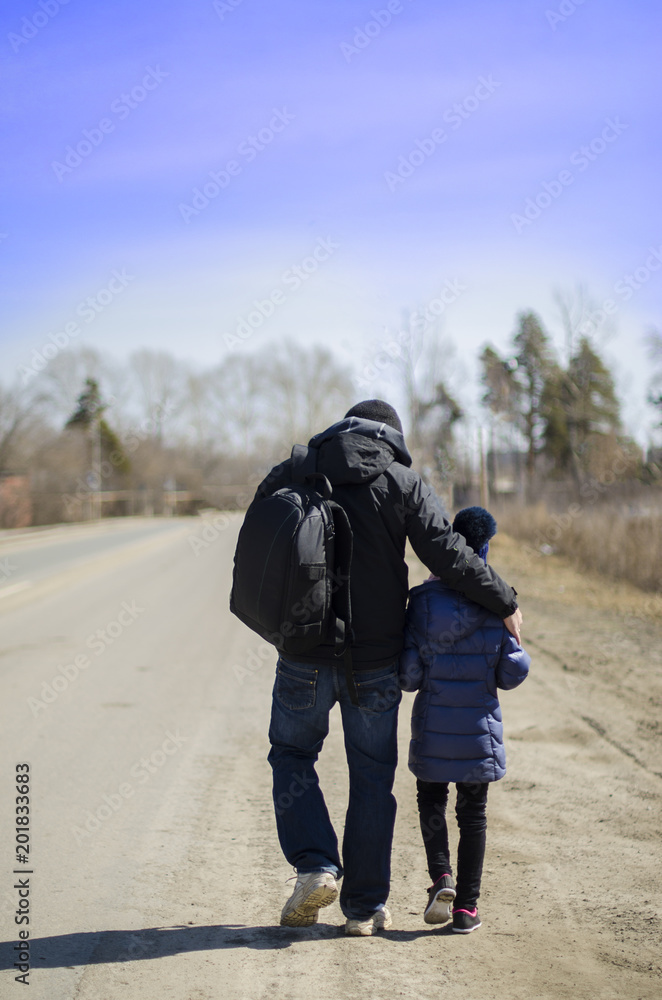 father and child go on the road on a bright sunny day