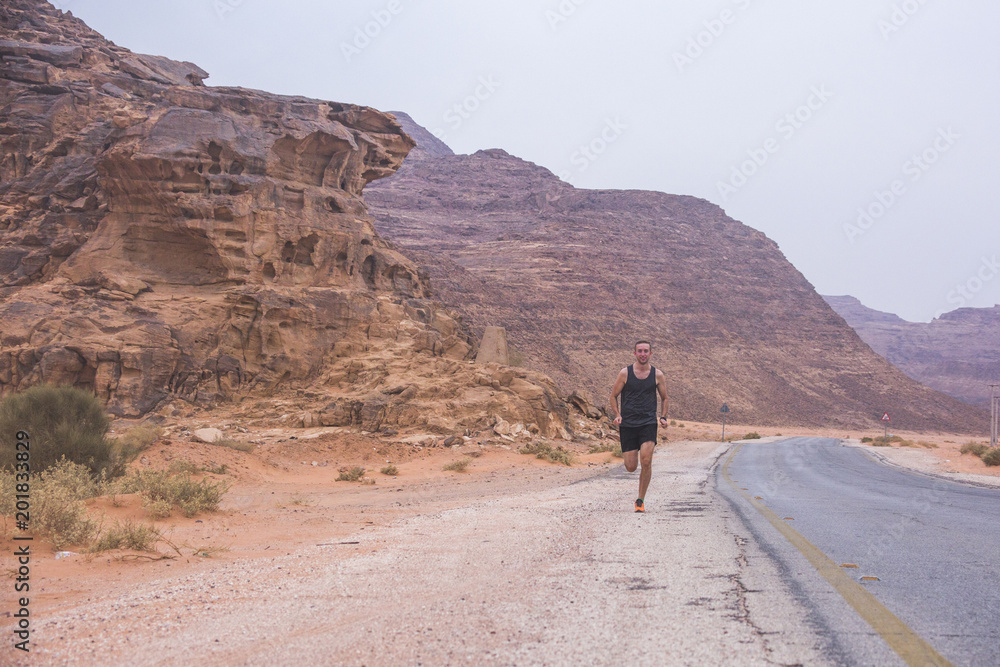 Man running in the Wadi Rum desert, Jordan Man running in the Wadi Rum desert, Jordan