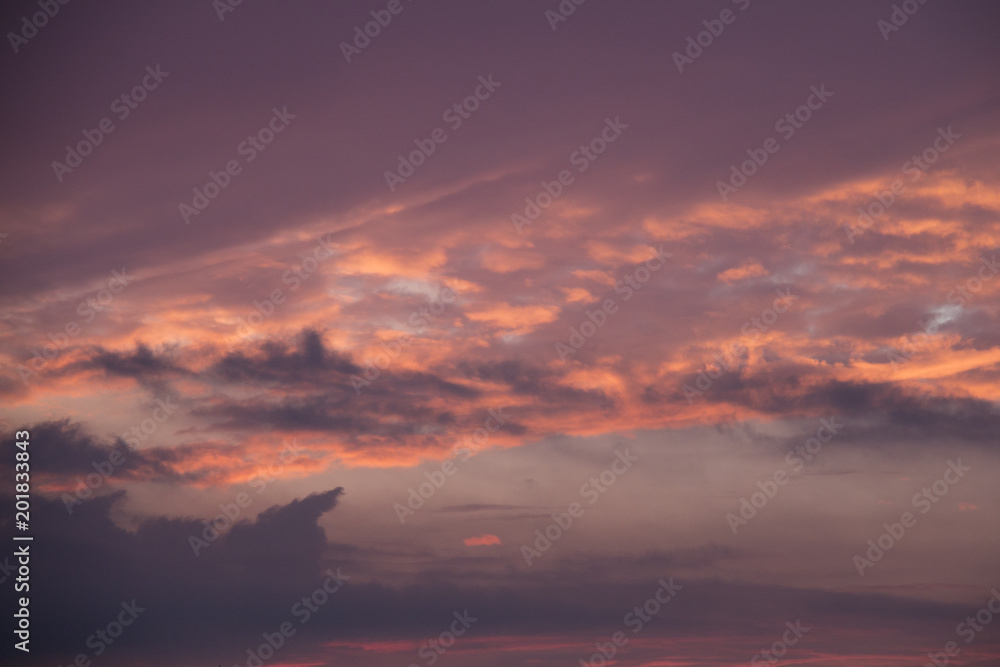 Glowing morning sky with the sun illuminating the sky and clouds with orange and yellow light before sunrise at dawn