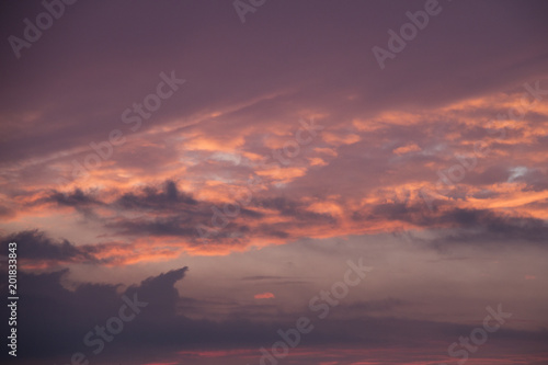 Glowing morning sky with the sun illuminating the sky and clouds with orange and yellow light before sunrise at dawn