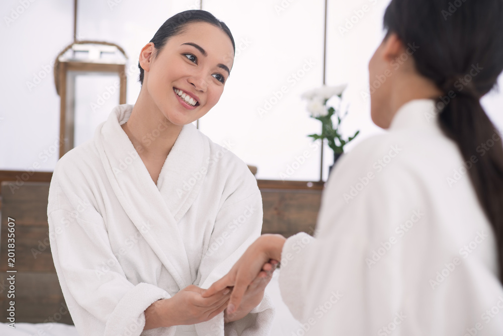 My congratulations. Nice pleasant woman looking at the engagement ring of her friend while being happy for her My congratulations. Nice pleasant woman looking at the engagement ring of her friend while being happy for her