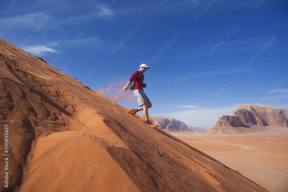 Man runs down the dune in the Wadi Rum desert, Jordan Man runs down the dune in the Wadi Rum desert, Jordan