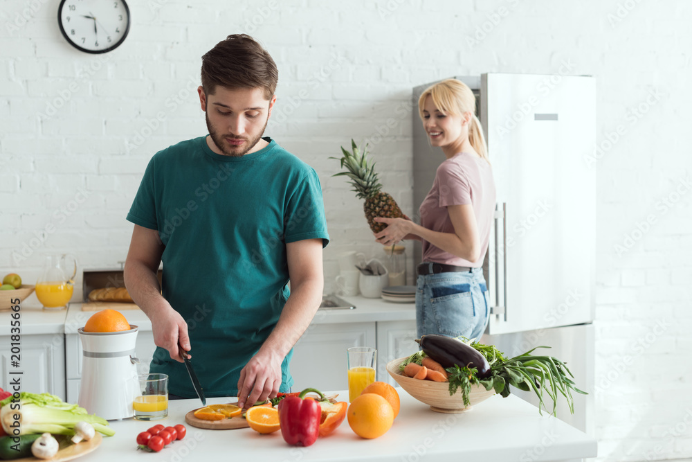 boyfriend cutting fruits for vegan meal at kitchen boyfriend cutting fruits for vegan meal at kitchen